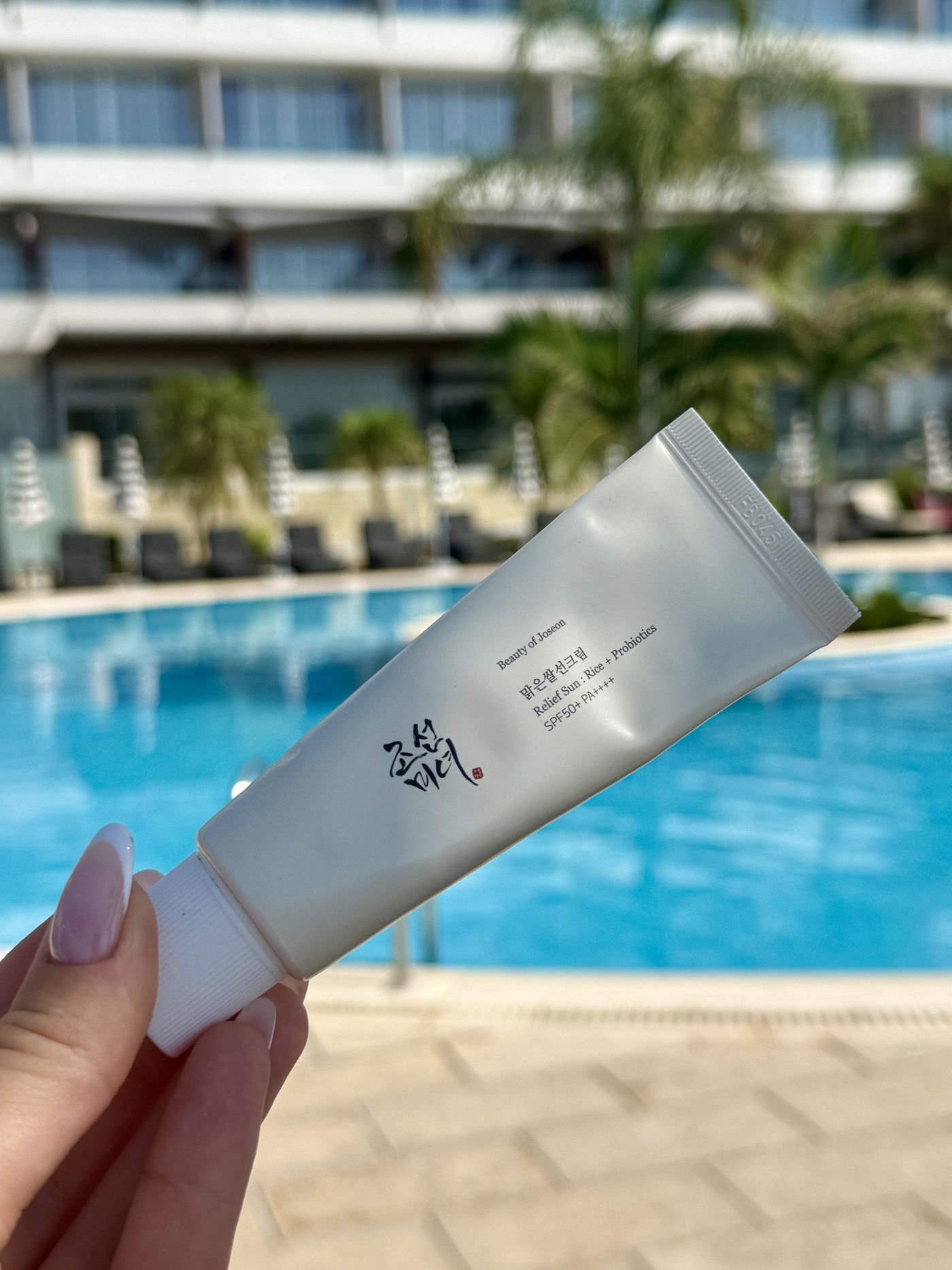 Close-up of the Beauty of Joseon Relief Sun SPF50+ tube by the pool