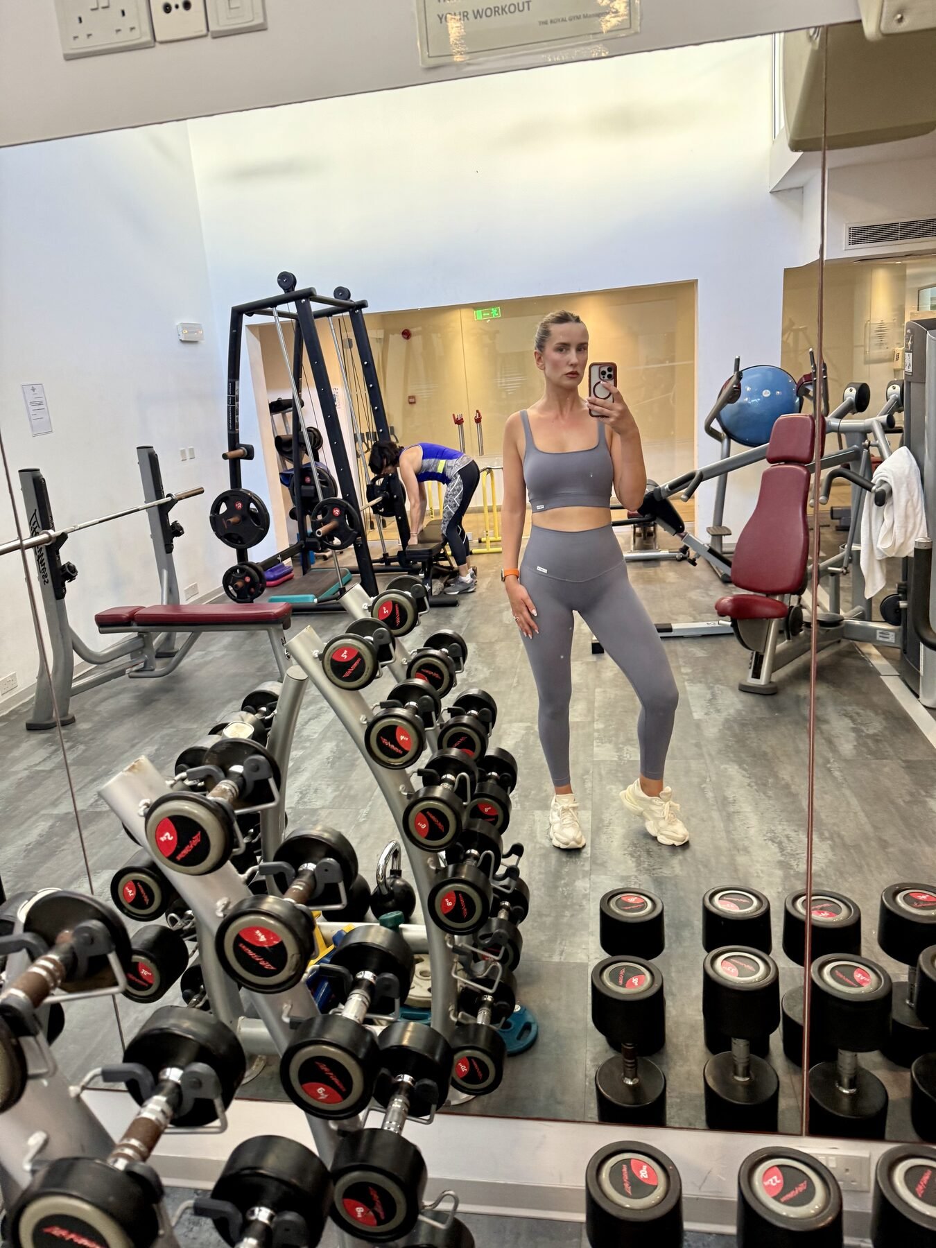 Gym mirror selfie of a woman using Optimum Nutrition Creatine Monohydrate as part of her workout routine