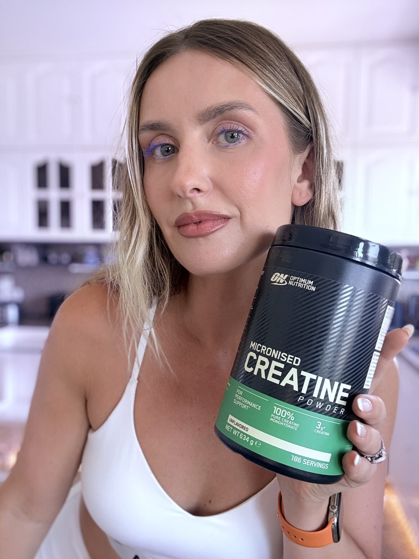 Woman holding Optimum Nutrition Micronized Creatine Monohydrate container for an honest product review